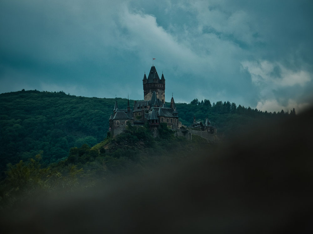 Burg Cochem auf einem Hügel unter bewölktem Himmel