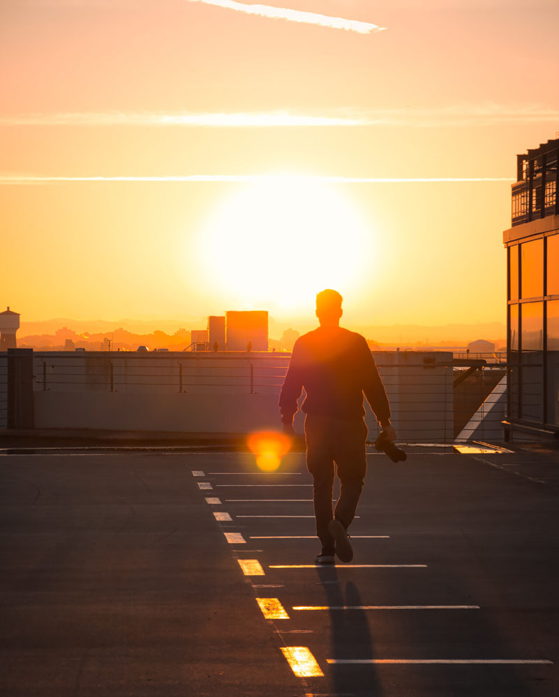Silhouette einer Person auf Parkdeck bei Sonnenuntergang
